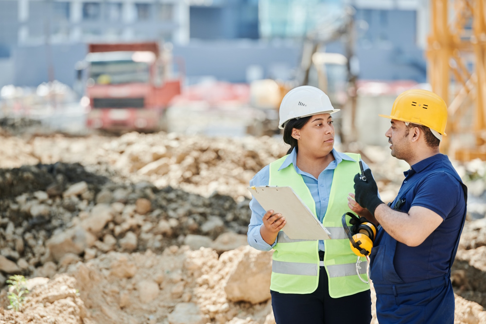 A man and a woman standing on a construction site.